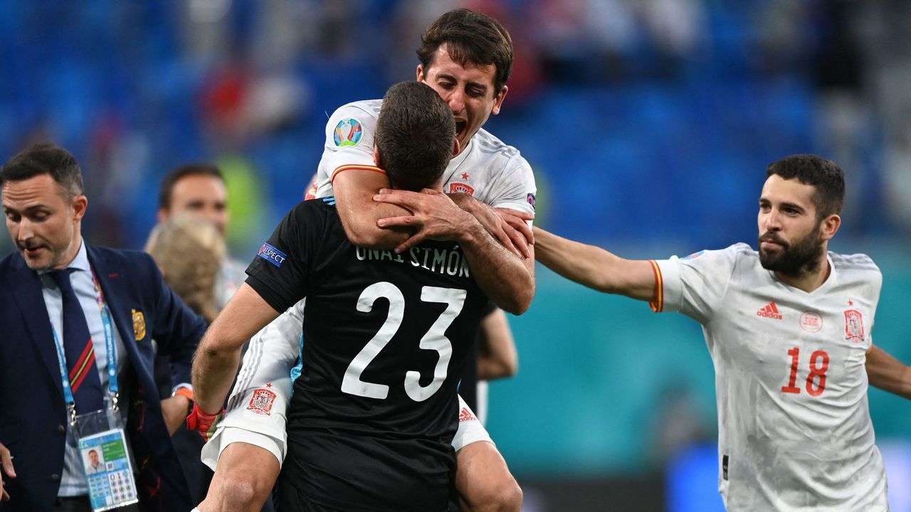 Spain's forward Mikel Oiarzabal (back) celebrates with Spain's goalkeeper Unai Simon after winning the penalty shootout during the UEFA EURO 2020 quarter-final football match between Switzerland and Spain at the Saint Petersburg Stadium in Saint Petersburg on July 2, 2021.