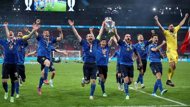 Italy's Giorgio Chiellini and Leonardo Bonucci carry the trophy and celebrate with team-mates after winning the penalty shoot-out after the UEFA Euro 2020 Final at Wembley Stadium, London. Picture date: Sunday July 11, 2021.