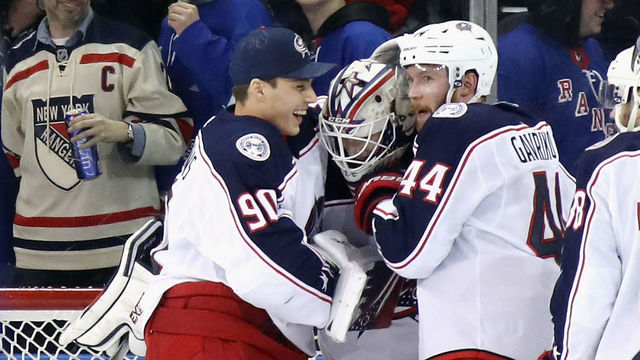 NEW YORK, NEW YORK - JANUARY 19: Fellow Latvia born goaltender Elvis Merzlikins #90 of the Columbus Blue Jackets reaches in to congratulate Matiss Kivlenieks #80 on his first NHL win in his first NHL game against the New York Rangers at Madison Square Garden on January 19, 2020 in New York City. The Blue Jackets defeated the Rangers 2-1.
