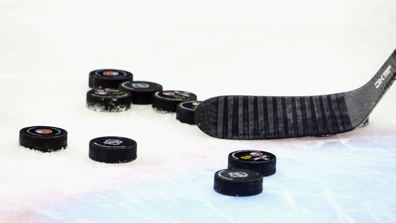 UNIONDALE, NEW YORK - JUNE 03: A close-up view of a stick and pucks during warm-ups prior to the game between the Boston Bruins and the New York Islanders in Game Three of the Second Round of the 2021 NHL Stanley Cup Playoffs at the Nassau Coliseum on June 03, 2021 in Uniondale, New York. The Bruins defeated the Islanders 2-1 in overtime.