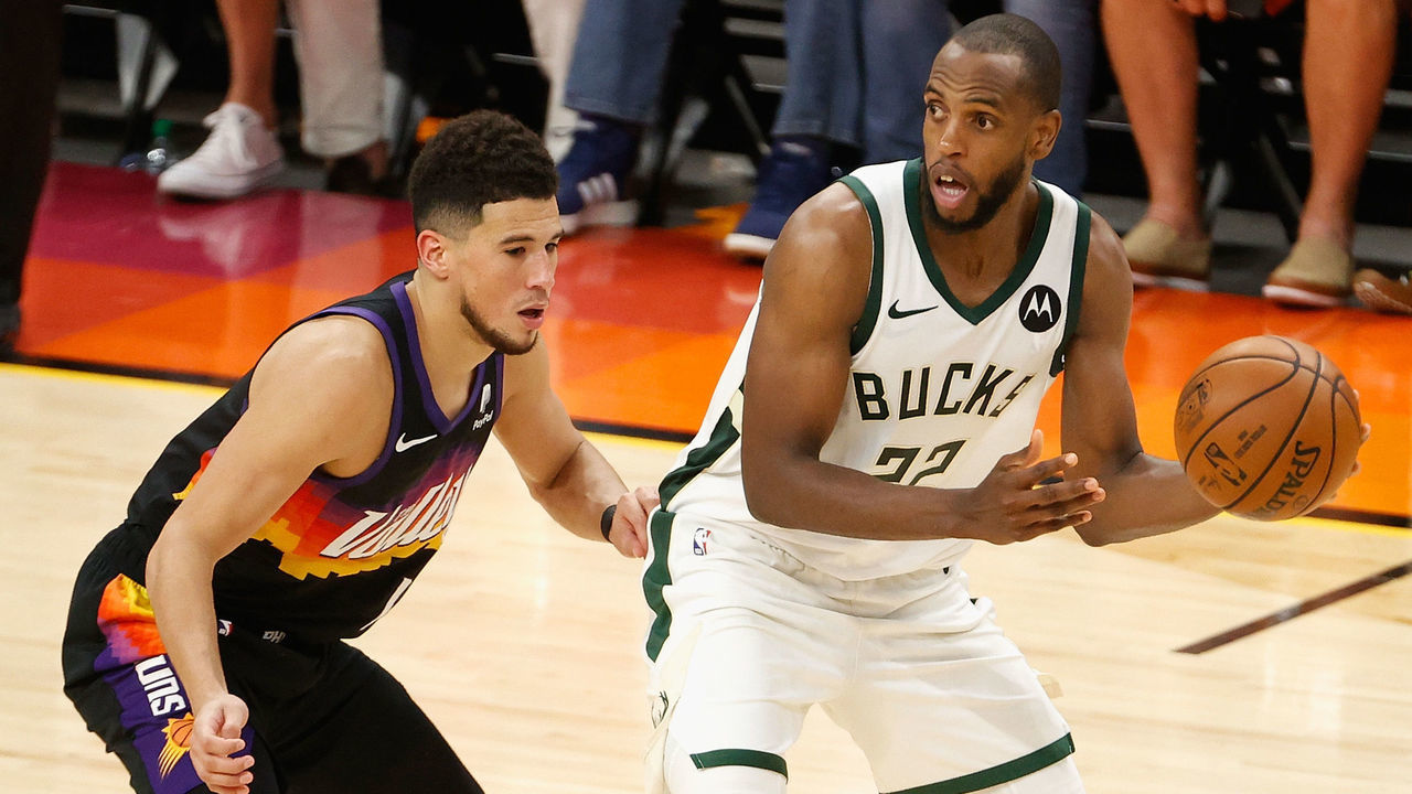 PHOENIX, ARIZONA - JULY 17: Khris Middleton #22 of the Milwaukee Bucks looks to pass around Devin Booker #1 of the Phoenix Suns in the second half of game five of the NBA Finals at Footprint Center on July 17, 2021 in Phoenix, Arizona. The Bucks defeated the Suns 123-119.