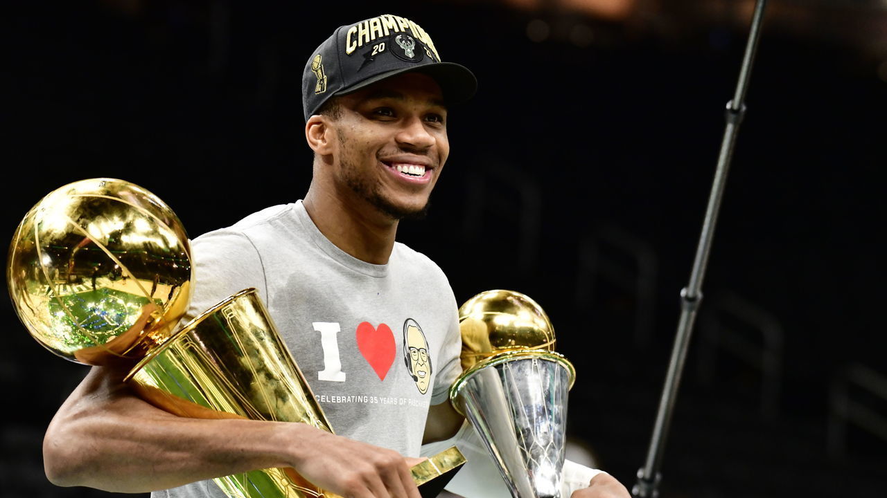 MILWAUKEE, WI - JULY 20: Giannis Antetokounmpo #34 of the Milwaukee Bucks holds the Bill Russell NBA Finals MVP Award and Larry O'Brien Trophy after defeating the Phoenix Suns in Game Six to win the 2021 NBA Finals during Game Six of the 2021 NBA Finals on July 20, 2021 at the Fiserv Forum Center in Milwaukee, Wisconsin. Mandatory Copyright Notice: Copyright 2021 NBAE .