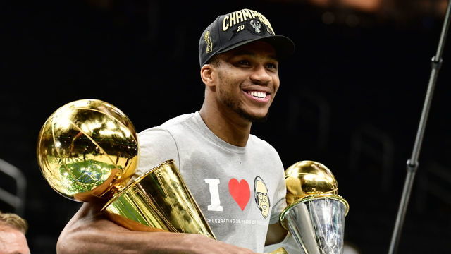 MILWAUKEE, WI - JULY 20: Giannis Antetokounmpo #34 of the Milwaukee Bucks holds the Bill Russell NBA Finals MVP Award and Larry O'Brien Trophy after defeating the Phoenix Suns in Game Six to win the 2021 NBA Finals during Game Six of the 2021 NBA Finals on July 20, 2021 at the Fiserv Forum Center in Milwaukee, Wisconsin. Mandatory Copyright Notice: Copyright 2021 NBAE .