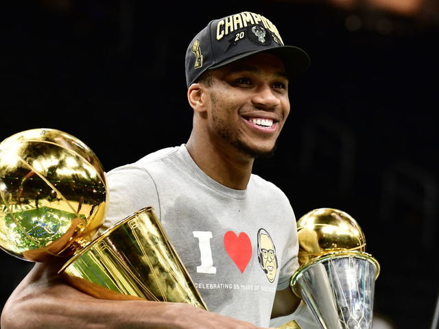 MILWAUKEE, WI - JULY 20: Giannis Antetokounmpo #34 of the Milwaukee Bucks holds the Bill Russell NBA Finals MVP Award and Larry O'Brien Trophy after defeating the Phoenix Suns in Game Six to win the 2021 NBA Finals during Game Six of the 2021 NBA Finals on July 20, 2021 at the Fiserv Forum Center in Milwaukee, Wisconsin. Mandatory Copyright Notice: Copyright 2021 NBAE .