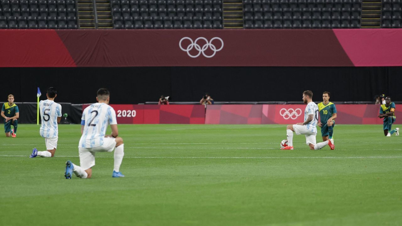 Players of Argentina and Australia kneel on the pitch before the start of the Tokyo 2020 Olympic Games men's group C first round football match between Argentina and Australia at the Sapporo Dome in Sapporo on July 22, 2021.