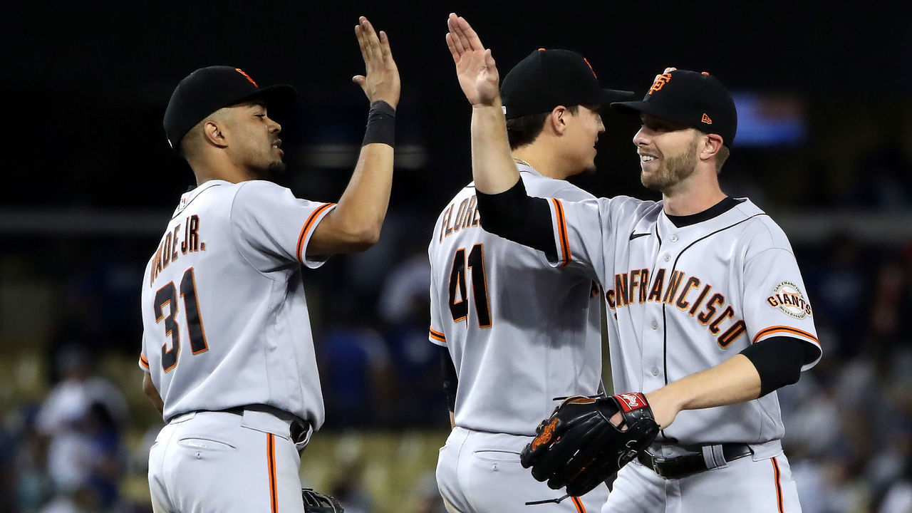 LOS ANGELES, CALIFORNIA - JULY 22: LaMonte Wade Jr. #31, Wilmer Flores #41 and Austin Slater #13 of the San Francisco Giants celebrate a 5-3 win against the Los Angeles Dodgers at Dodger Stadium on July 22, 2021 in Los Angeles, California.