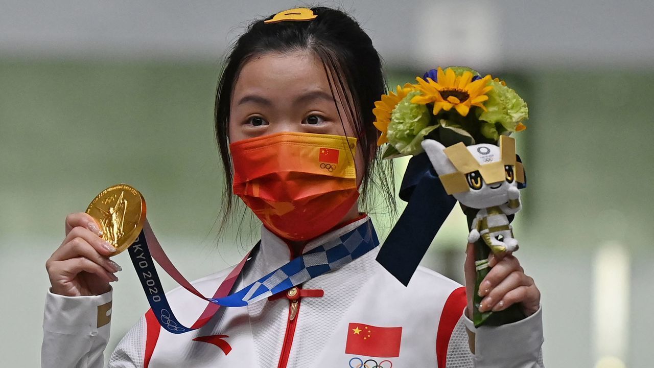 Gold medal winner China's Yang Qian celebrates on the podium after winning the women's 10m air rifle final during the Tokyo 2020 Olympic Games at the Asaka Shooting Range in the Nerima district of Tokyo on July 24, 2021.