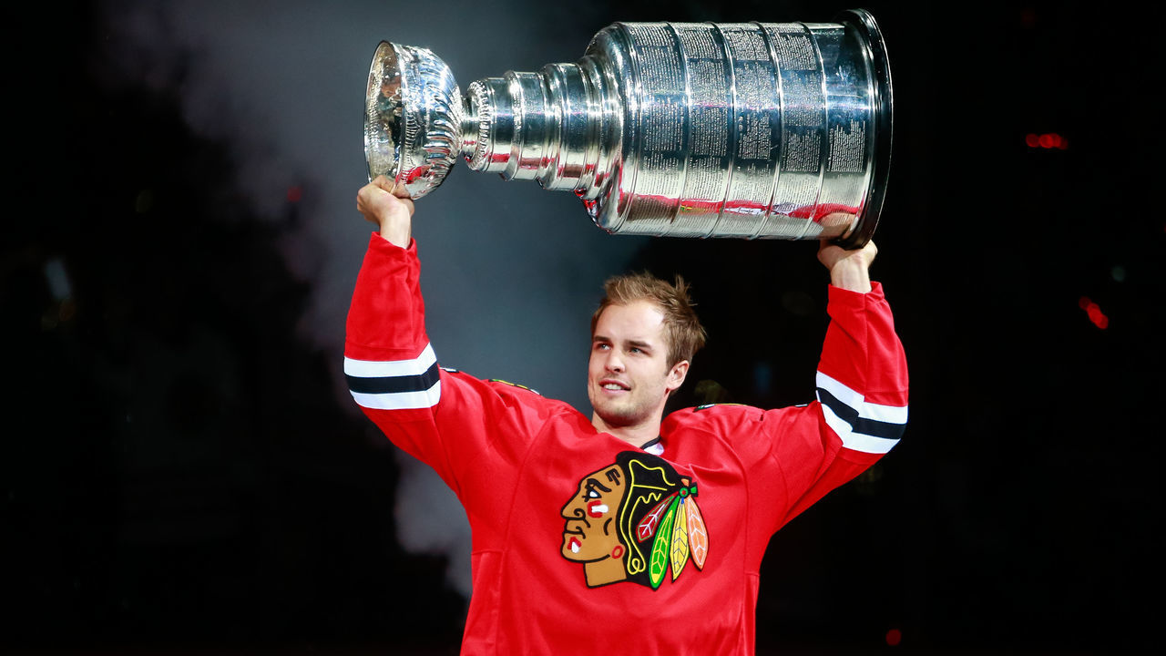 CHICAGO, IL - OCTOBER 07: Niklas Hjalmarsson #4 of the Chicago Blackhawks raises the Stanley Cup during pre-game ceremonies of the the season opener against the New York Rangers during an NHL game at the United Center on October 7, 2015 in Chicago, Illinois.