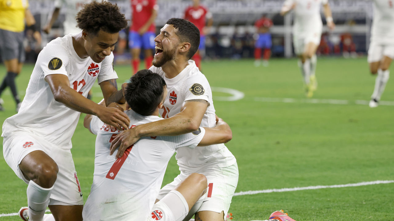 ARLINGTON, TEXAS - JULY 25: Tajon Buchanan #12 of Canada and teammates Jonathan Osorio #21 and Stephen Eustaquio #7 celebrate a goal by Eustaquio in the second half of a 2021 CONCACAF Gold Cup Quarterfinals match at AT&T Stadium on July 25, 2021 in Arlington, Texas.