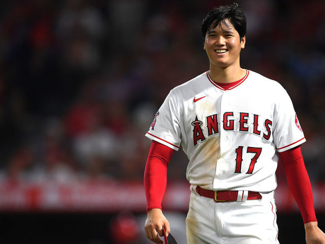 ANAHEIM, CA - JULY 26: Shohei Ohtani #17 of the Los Angeles Angels smiles at the umpires waiting to check his glove and hat after the sixth inning of the game against the Colorado Rockies at Angel Stadium of Anaheim on July 26, 2021 in Anaheim, California.