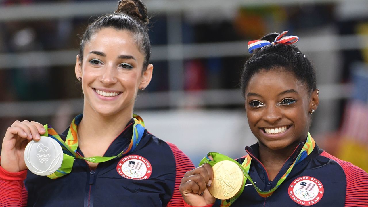 US gymnast Alexandra Raisman and US gymnast Simone Biles (R) celebrate on the podium of the women's floor event final of the Artistic Gymnastics at the Olympic Arena during the Rio 2016 Olympic Games in Rio de Janeiro on August 16, 2016. / AFP / Toshifumi KITAMURA