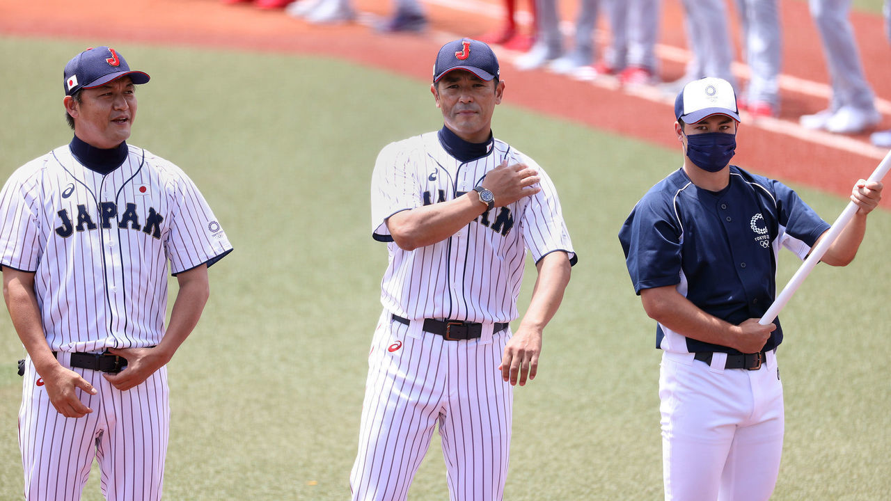 FUKUSHIMA, JAPAN - JULY 28: Team manager Atsunori Inaba (C) and coach Makoto Kaneko (L) of Team Japan look on during pregame ceremonies before the game against Team Dominican Republic the baseball opening round Group A game on day five of the Tokyo 2020 Olympic Games at Fukushima Azuma Baseball Stadium on July 28, 2021 in Fukushima, Japan.