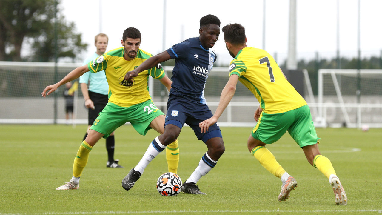NORWICH, ENGLAND - JULY 23: Brahima Diarra of Huddersfield Town is challengeged by Norwich City players during the game between Norwich City and Huddersfield Town on July 23, 2021 in Norwich, England.