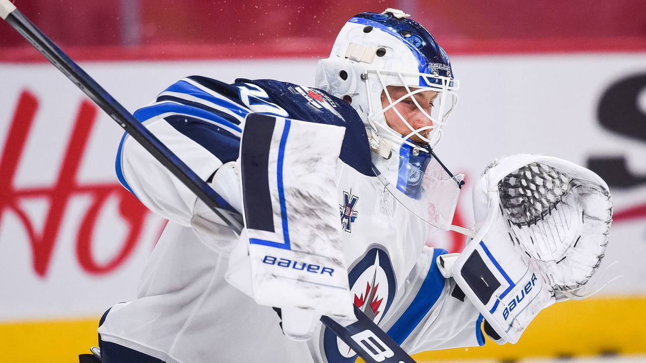 MONTREAL, QC - JUNE 06: Winnipeg Jets goalie Laurent Brossoit (30) takes shots at warm-up before NHL Stanley Cup Playoffs second round game 3 between the Winnipeg Jets versus the Montreal Canadiens on June 06, 2021, at Bell Centre in Montreal, QC