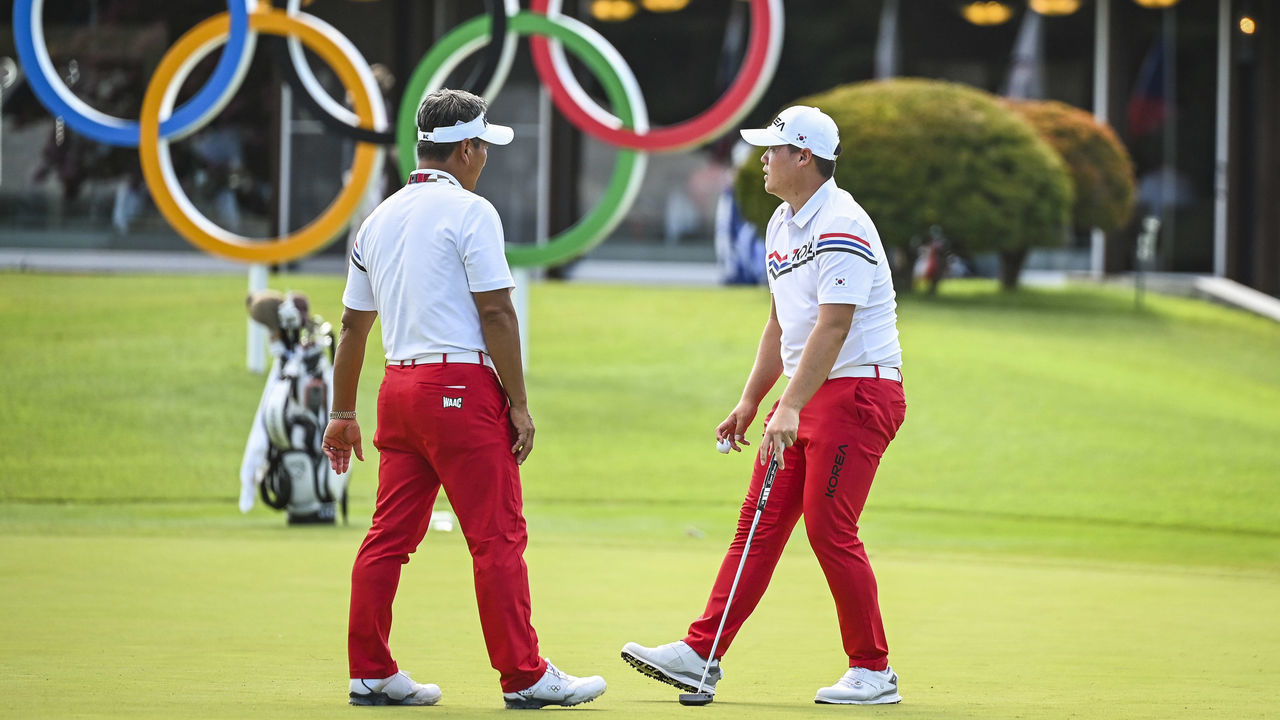 KAWAGOE, JAPAN - JULY 27: Sungjae Im and K.J. Choi of Team South Korea work on the putting green in front of the Olympic Rings during practice for the Mens Golf Competition of the Tokyo Olympic Games on the East Course at Kasumigaseki Country Club on July 27, 2021 in Kawagoe, Saitama, Japan.