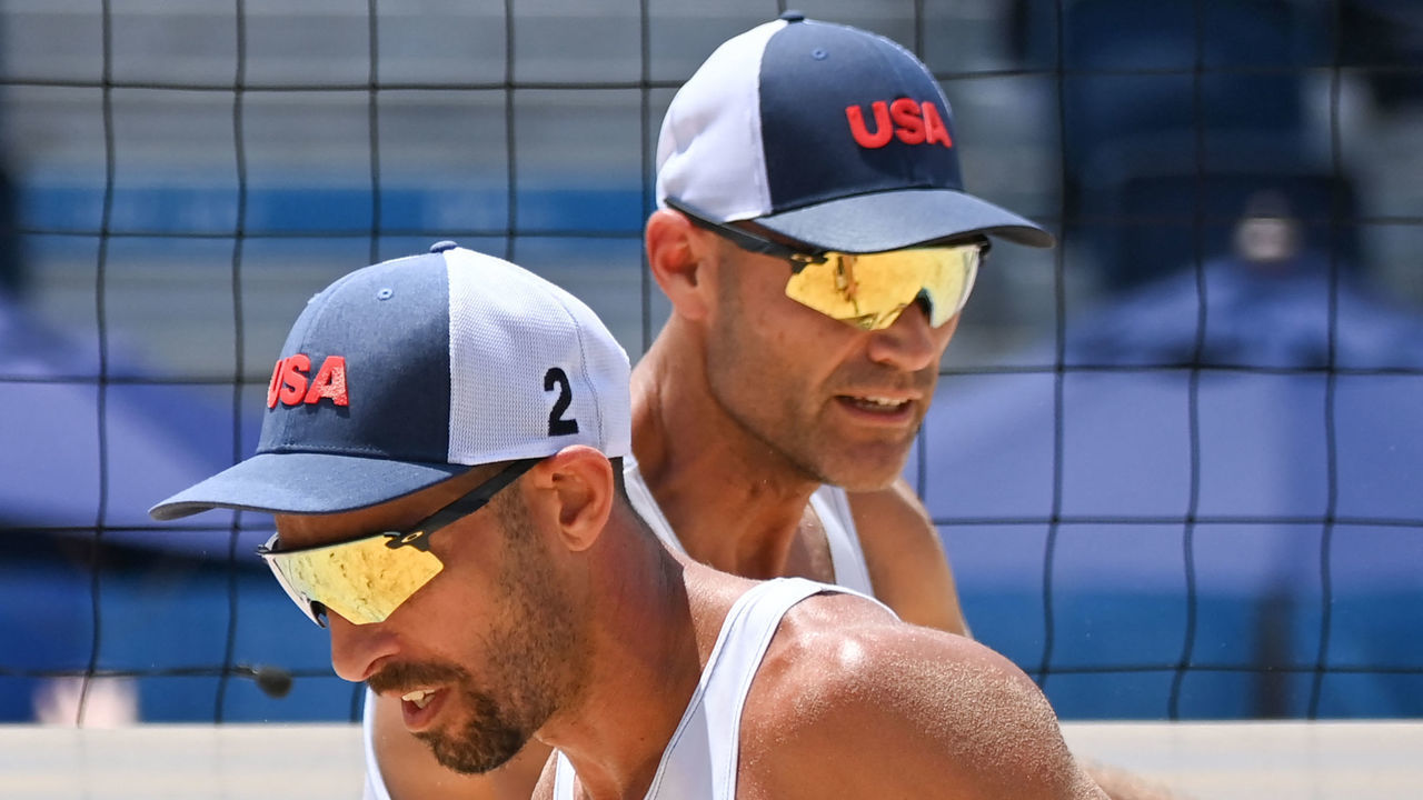 USA's Nicholas Lucena (L) walks past partner Philip Dalhausser in their men's preliminary beach volleyball pool D match between the USA and Argentina during the Tokyo 2020 Olympic Games at Shiokaze Park in Tokyo on July 29, 2021.