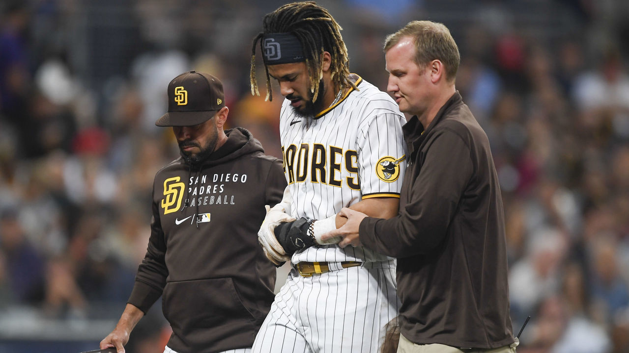 SAN DIEGO, CA - JULY 30: Fernando Tatis Jr. #23 of the San Diego Padres is helped off the field by manager Jayce Tingler and a trainer after he was injured during the first inning of a baseball game against the Colorado Rockies at Petco Park on July 30, 2021 in San Diego, California.