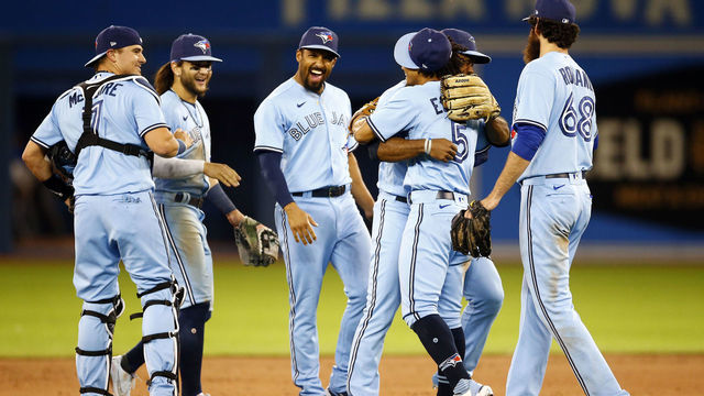 TORONTO, ON - JULY 30: Teoscar Henrnandez #37 of the Toronto Blue Jays hugs Santiago Espinal #5 after he made a bare handed catch for the final out of a MLB game against the Kansas City Royals at Rogers Centre on July 30, 2021 in Toronto, Canada.
