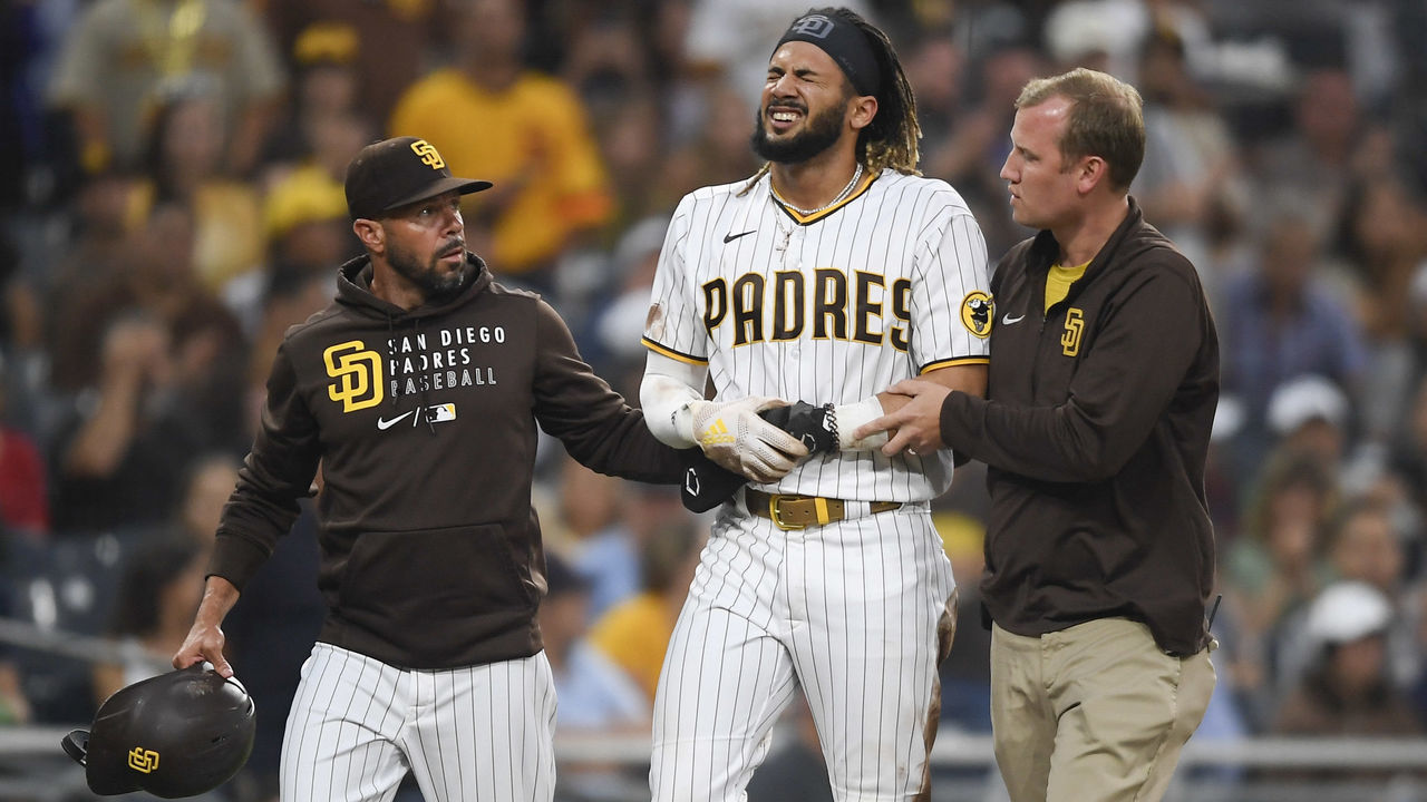 SAN DIEGO, CA - JULY 30: Fernando Tatis Jr. #23 of the San Diego Padres is helped off the field by manager Jayce Tingler and a trainer after he was injured during the first inning of a baseball game against the Colorado Rockies at Petco Park on July 30, 2021 in San Diego, California.