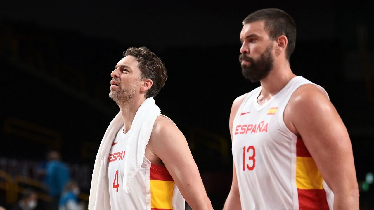 Spain's Pau Gasol Saez and Marc Gasol (R) walk on the court after their victory at the end of the men's preliminary round group C basketball match between Spain and Argentina during the Tokyo 2020 Olympic Games at the Saitama Super Arena in Saitama on July 29, 2021.