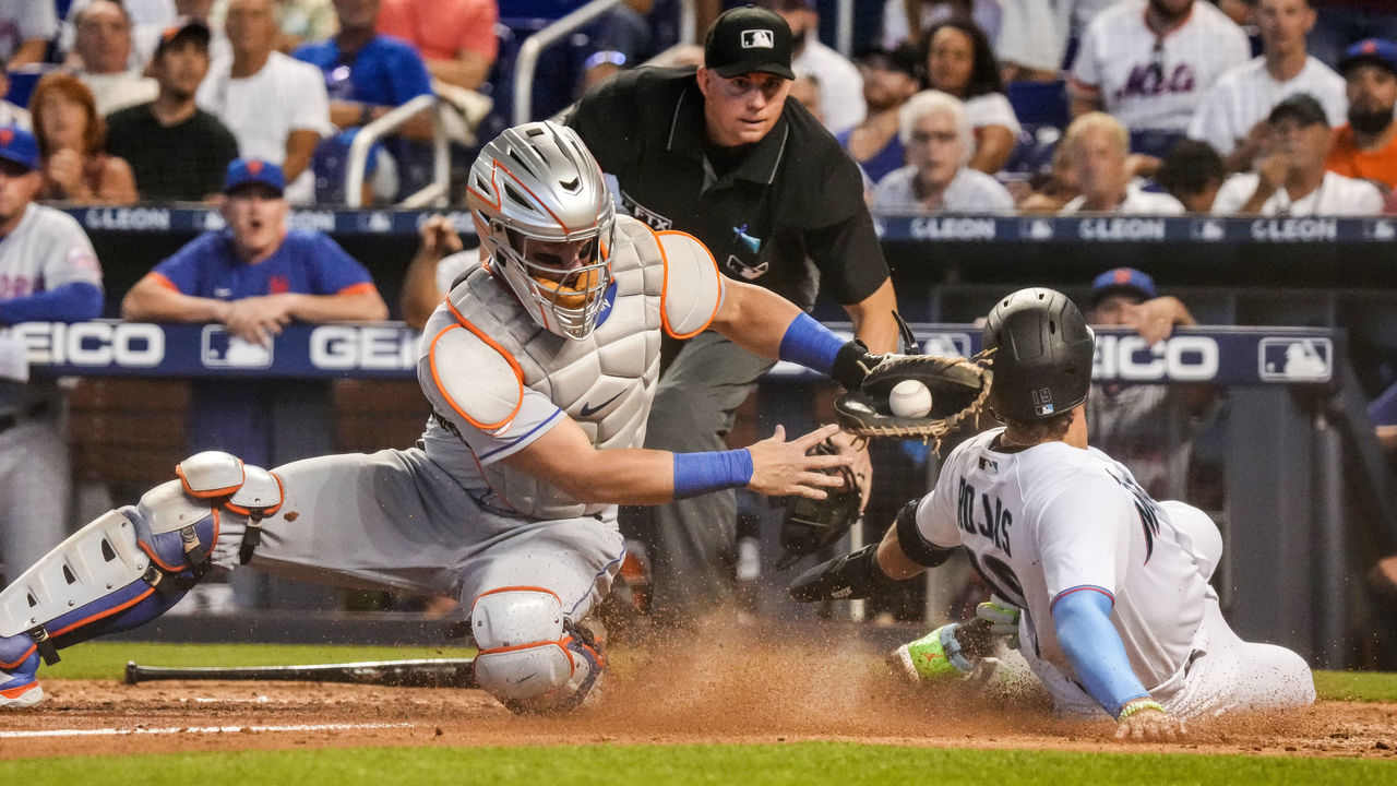 MIAMI, FLORIDA - AUGUST 05: Miguel Rojas #19 of the Miami Marlins avoids the tag sliding into home plate from Tomás Nido #3 of the New York Mets in the eighth inning against the New York Mets at loanDepot park on August 05, 2021 in Miami, Florida.