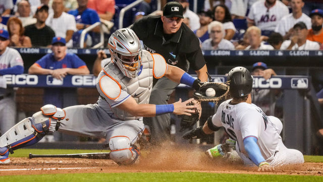 MIAMI, FLORIDA - AUGUST 05: Miguel Rojas #19 of the Miami Marlins avoids the tag sliding into home plate from Tomás Nido #3 of the New York Mets in the eighth inning against the New York Mets at loanDepot park on August 05, 2021 in Miami, Florida.