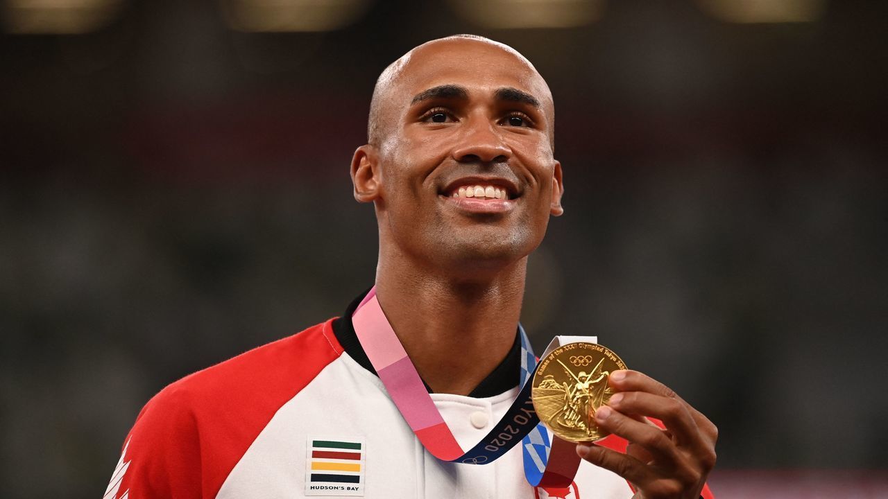 Gold medallist Canada's Damian Warner celebrates on the podium during the medal ceremony for the men's decathlon event during the Tokyo 2020 Olympic Games at the Olympic Stadium in Tokyo on August 6, 2021.