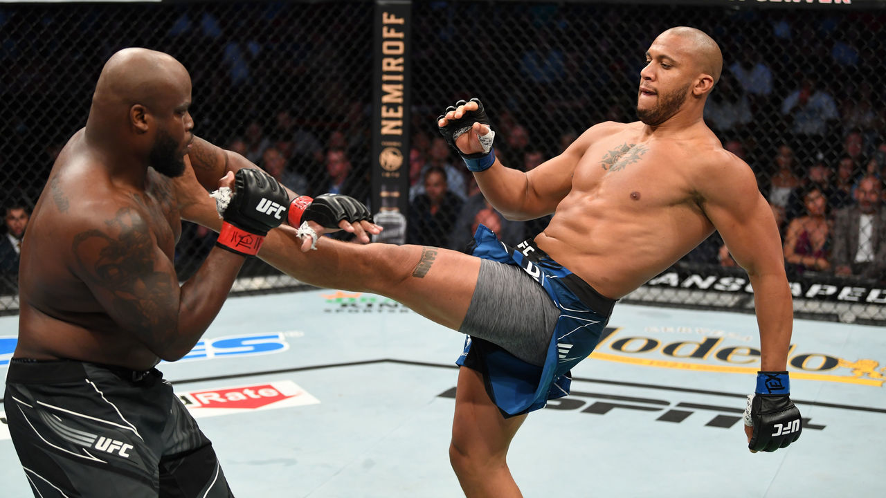 HOUSTON, TEXAS - AUGUST 07: (R-L) Ciryl Gane of France kicks Derrick Lewis in their interim heavyweight title bout during the UFC 265 event at Toyota Center on August 07, 2021 in Houston, Texas.
