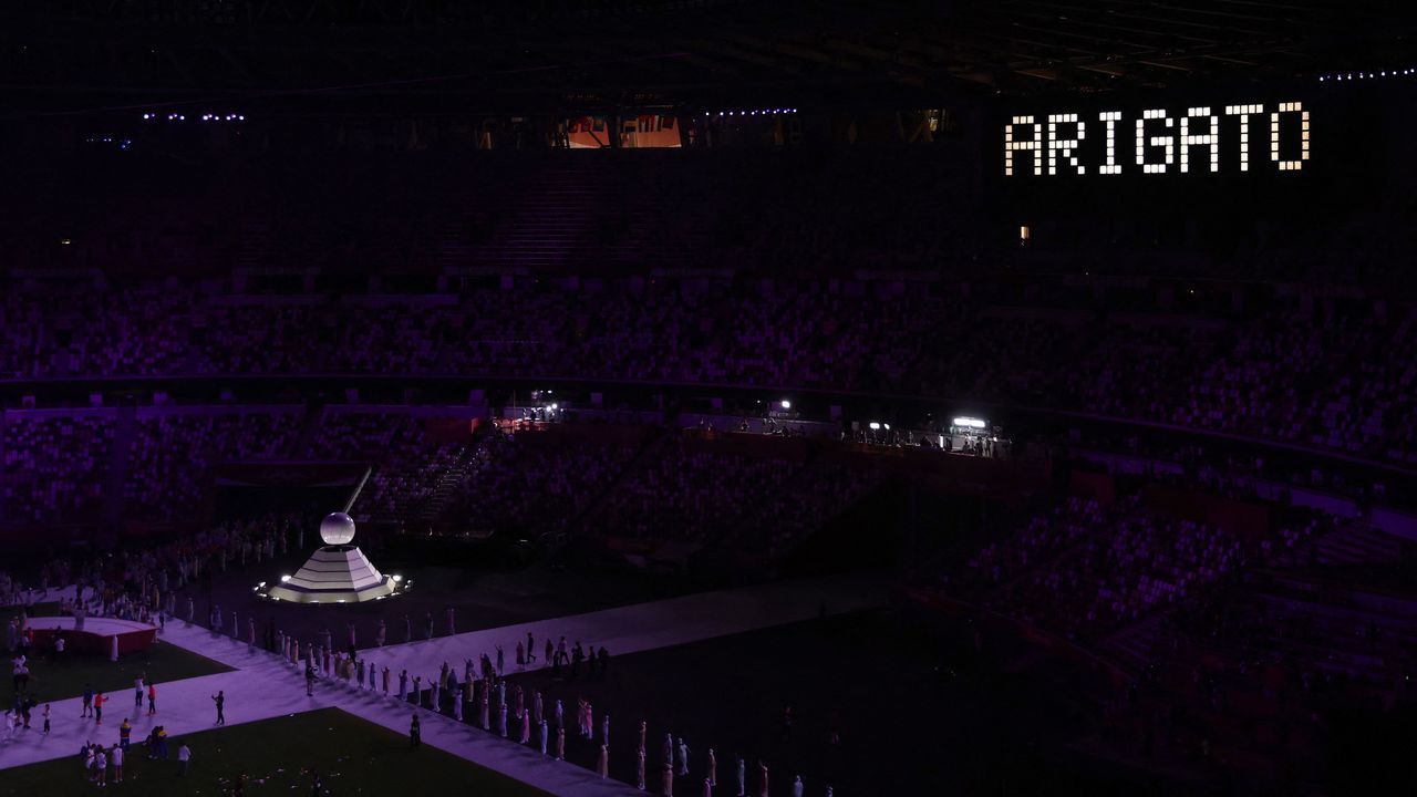 The word "Arigato", Japanese for "Thank You", is displayed after the Olympic cauldron (L) closed and the Olympic flame was extinguised during the closing ceremony of the Tokyo 2020 Olympic Games, at the Olympic Stadium, in Tokyo, on August 8, 2021.