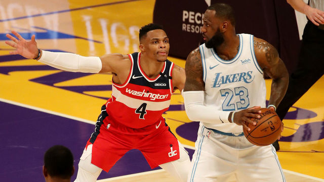 LOS ANGELES, CALIFORNIA - FEBRUARY 22: Russell Westbrook #4 of the Washington Wizards guards LeBron James #23 of the Los Angeles Lakers during the fourth quarter at Staples Center on February 22, 2021 in Los Angeles, California.