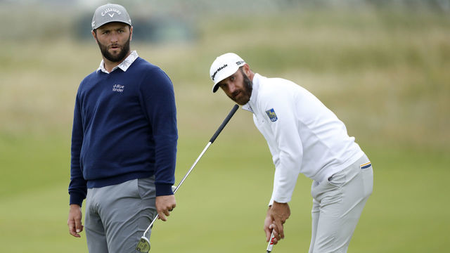 SANDWICH, ENGLAND - JULY 14: Dustin Johnson of the United States plays a shot on the green of the fifth hole as Jon Rahm of Spain looks on during a practice round ahead of The 149th Open at Royal St George’s Golf Club on July 14, 2021 in Sandwich, England.