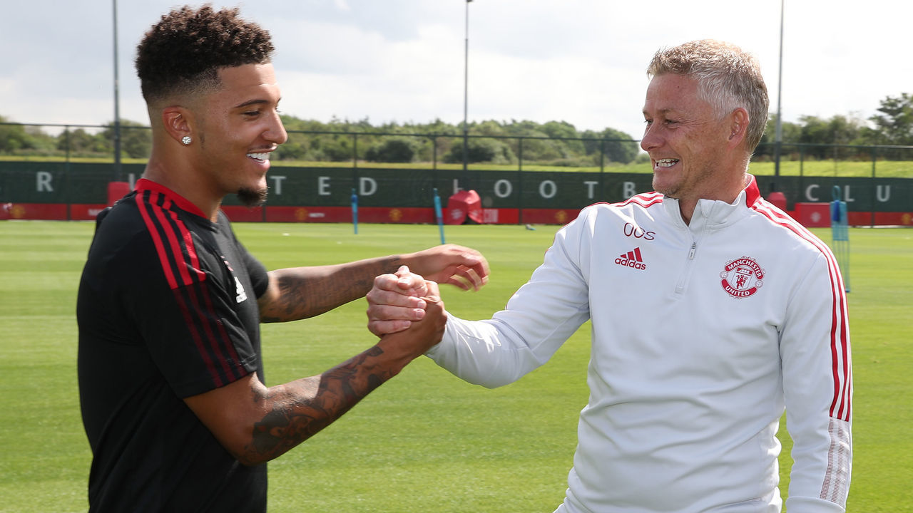 MANCHESTER, ENGLAND - AUGUST 09: (EXCLUSIVE COVERAGE) Manager Ole Gunnar Solskjaer of Manchester United greets Jadon Sancho of Manchester United ahead of a first team training session at Carrington Training Ground on August 09, 2021 in Manchester, England.