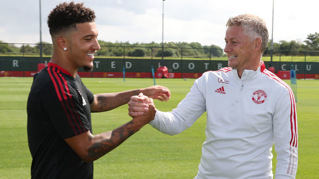 MANCHESTER, ENGLAND - AUGUST 09: (EXCLUSIVE COVERAGE) Manager Ole Gunnar Solskjaer of Manchester United greets Jadon Sancho of Manchester United ahead of a first team training session at Carrington Training Ground on August 09, 2021 in Manchester, England.