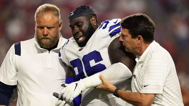 GLENDALE, ARIZONA - AUGUST 13: Defensive tackle Neville Gallimore #96 of the Dallas Cowboys is helped by trainers after an injury in the second half of the NFL preseason game against the Arizona Cardinals at State Farm Stadium on August 13, 2021 in Glendale, Arizona.