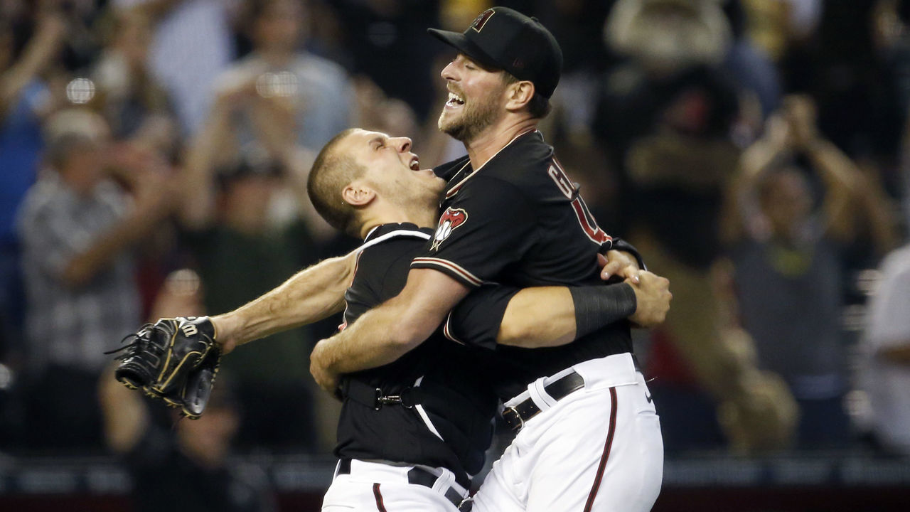 PHOENIX, ARIZONA - AUGUST 14: Starting pitcher Tyler Gilbert #49 of the Arizona Diamondbacks jumps into the arms of catcher Daulton Varsho #12 of the Diamondbacks as they celebrate Gilbert's complete game shutout against the San Diego Padres during the MLB game at Chase Field on August 14, 2021 in Phoenix, Arizona. The Diamondbacks defeated the Padres 7-0.