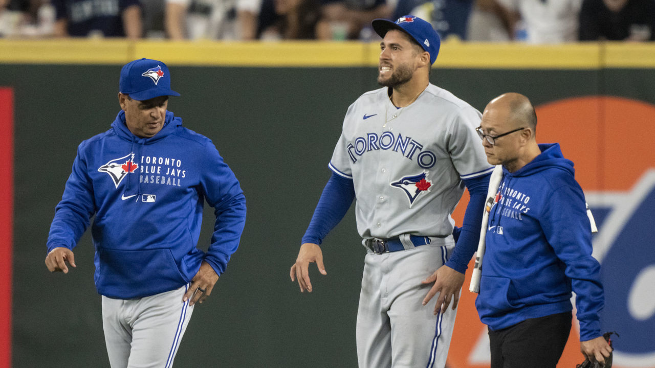 SEATTLE, WA - AUGUST 14: Centerfielder George Springer #4 of the Toronto Blue Jays walks off the field with manager Charlie Montoyo and training personnel after injuring his ankle during the seventh inning of a game against the Seattle Mariners at T-Mobile Park on August 14, 2021 in Seattle, Washington.