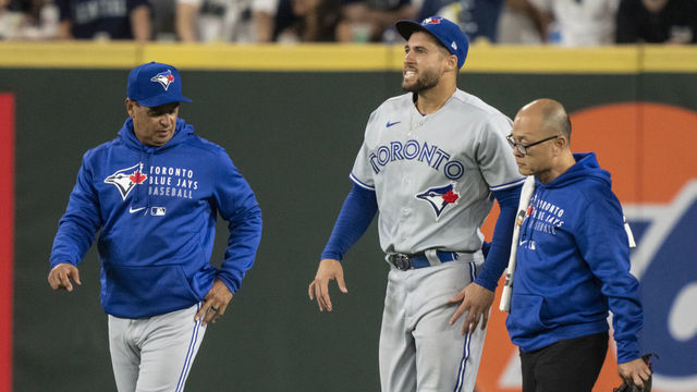 SEATTLE, WA - AUGUST 14: Centerfielder George Springer #4 of the Toronto Blue Jays walks off the field with manager Charlie Montoyo and training personnel after injuring his ankle during the seventh inning of a game against the Seattle Mariners at T-Mobile Park on August 14, 2021 in Seattle, Washington.