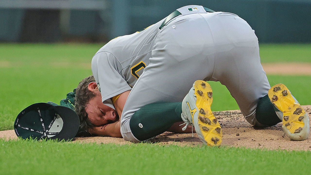 CHICAGO, ILLINOIS - AUGUST 17: Starting pitcher Chris Bassitt #40 of the Oakland Athletics lies on the ground after being hit in the head by a line drive from Brian Goodwin of the Chicago White Sox in the second inning at Guaranteed Rate Field on August 17, 2021 in Chicago, Illinois.