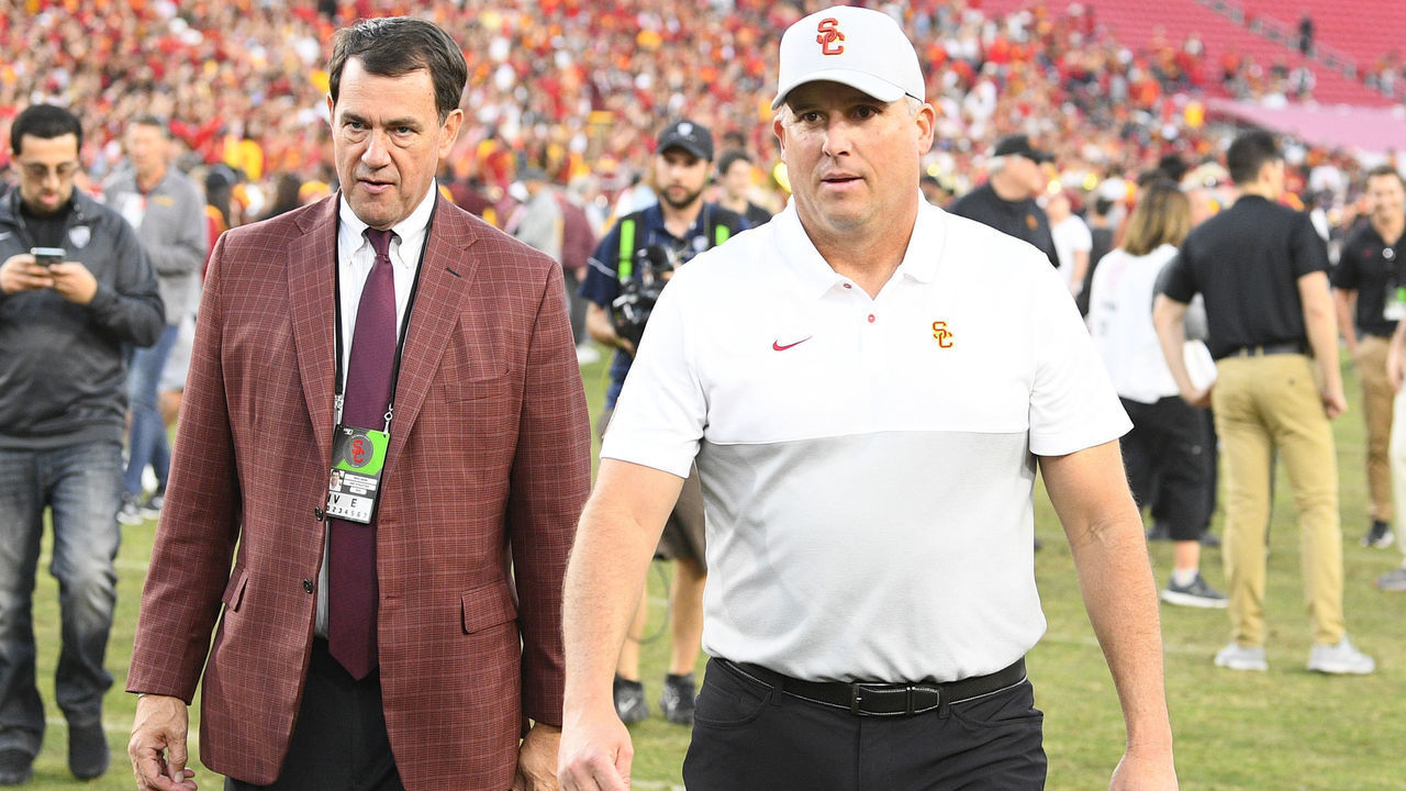 LOS ANGELES, CA - NOVEMBER 23: USC Trojans head coach Clay Helton and athletic director Mike Bohn walk off the field after a college football game between the UCLA Bruins and the USC Trojans on November 23, 2019, at Los Angeles Memorial Coliseum in Los Angeles, CA.