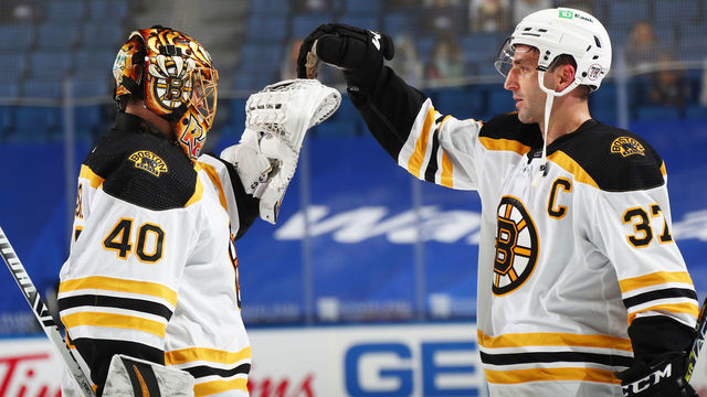 BUFFALO, NY - APRIL 20: Tuukka Rask #40 and Patrice Bergeron celebrate their 2-0 victory against the Buffalo Sabres following an NHL game on April 20, 2021 at KeyBank Center in Buffalo, New York.