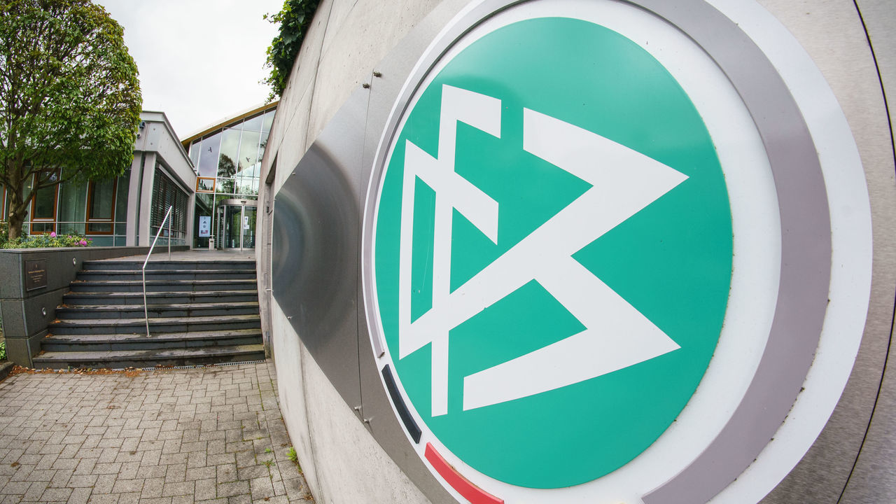 25 May 2021, Hessen, Frankfurt/Main: The logo hangs at the entrance to the headquarters of the German Football Association (DFB). Football coach Hansi Flick will become the new national coach after the European Championship this summer and will receive a contract until the home European Championship in 2024. The first major tournament for Flick will be the World Cup in Qatar in late autumn 2022. Photo: Frank Rumpenhorst/dpa/Frank Rumenhorst/dpa - IMPORTANT NOTE: In accordance with the regulations of the DFL Deutsche Fußball Liga and/or the DFB Deutscher Fußball-Bund, it is prohibited to use or have used photographs taken in the stadium and/or of the match in the form of sequence pictures and/or video-like photo series.