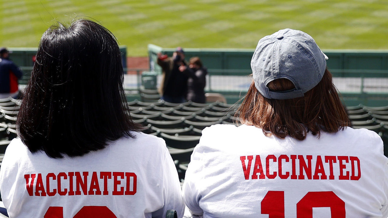 BOSTON, MASSACHUSETTS - APRIL 02: Fans wearing "Vaccinated" shirts sit the stands on Opening Day between the Boston Red Sox and the Baltimore Orioles at Fenway Park on April 02, 2021 in Boston, Massachusetts.