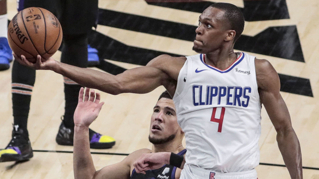 Sunday, June 20, 2021, Phoenix, Arizona - LA Clippers guard Rajon Rondo (4) slips past Phoenix Suns guard Devin Booker (1) for a layup late in Game one of the NBA Western Conference Finals at Phoenix Suns Arena. (Robert Gauthier/Los Angeles Times via Getty Images)