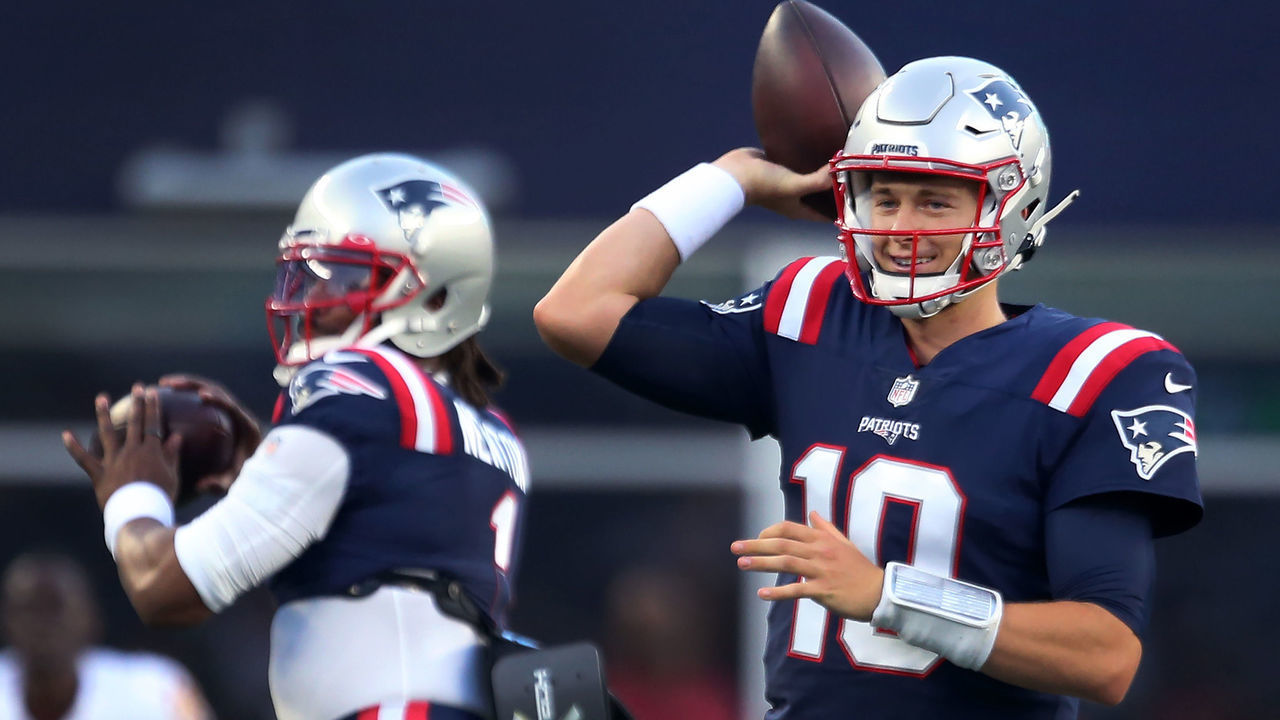 Foxborough, MA - August 12: New England Patriots quarterback Mac Jones is in the foreground at right, and Cam Newton is in the background at left during pre game warmups. The New England Patriots hosted the Washington Football Team in an NFL football pre season game at Gillette Stadium in Foxborough, MA on Aug. 12, 2021.