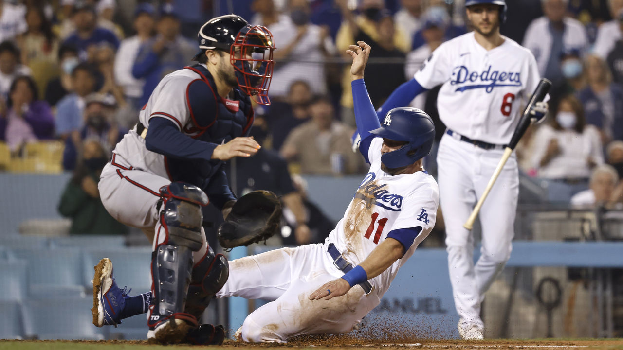 LOS ANGELES, CALIFORNIA - AUGUST 31: AJ Pollock #11 of the Los Angeles Dodgers slides into home safely to tie the game, 2-2, against the Atlanta Braves during the seventh inning at Dodger Stadium on August 31, 2021 in Los Angeles, California.