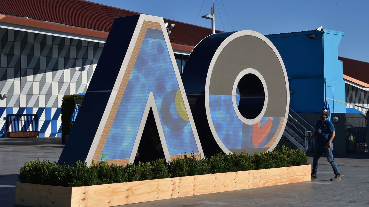 A worker checks on a logo for the Australian Open tennis tournament ahead of its start in Melbourne on January 14, 2018. / AFP PHOTO / PETER PARKS / -- IMAGE RESTRICTED TO EDITORIAL USE - STRICTLY NO COMMERCIAL USE --