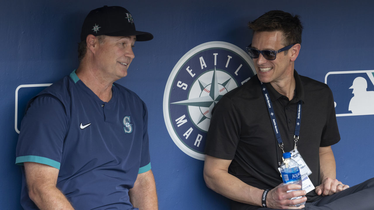 SEATTLE, WA - AUGUST 14: Seattle Mariners manager Scott Servais and general maanger Jerry Dipoto talk in the dugout before a game between the Toronto Blue Jays and the Seattle Mariners at T-Mobile Park on August 14, 2021 in Seattle, Washington. The Mariners won 9-3.