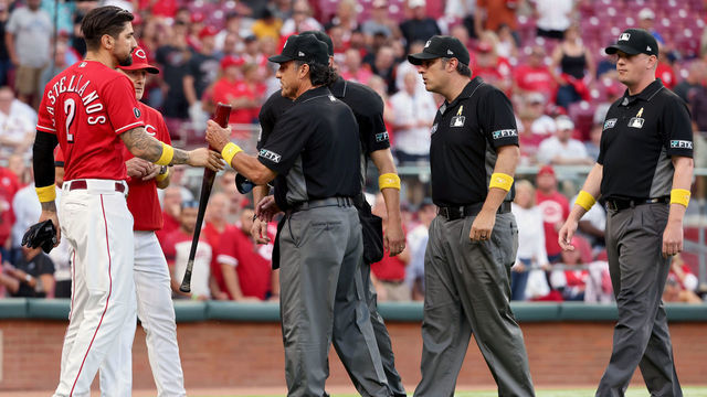 CINCINNATI, OHIO - SEPTEMBER 01: Umpire Phil Cuzzi inspects the bat used by Nick Castellanos #2 of the Cincinnati Reds in the second inning against the St. Louis Cardinals during game two of a doubleheader at Great American Ball Park on September 01, 2021 in Cincinnati, Ohio.