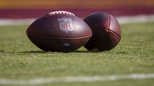 LANDOVER, MD - AUGUST 28: A detailed view of two NFL footballs with Baltimore Ravens logos are seen on the field before the preseason game between the Washington Football Team and the Baltimore Ravens at FedExField on August 28, 2021 in Landover, Maryland.