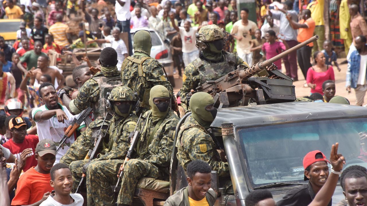 People celebrate in the streets with members of Guinea's armed forces after the arrest of Guinea's president, Alpha Conde, in a coup d'etat in Conakry, September 5, 2021. - Guinean special forces seized power in a coup on September 5, arresting the president and imposing an indefinite curfew in the poor west African country. "We have decided, after having taken the president, to dissolve the constitution," said a uniformed officer flanked by soldiers toting assault rifles in a video sent to AFP.